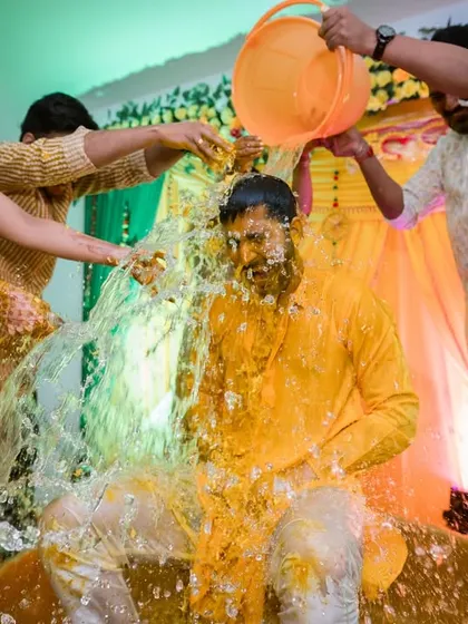 Another angle of the big splash. This wide shot shows the full extent of the fun, with multiple people involved in dousing the groom.