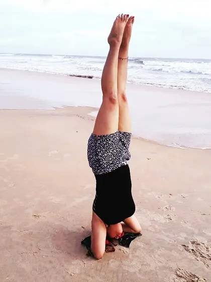 Practicing Sirsasana (Headstand) on the beach. The sound of the waves and the soft sand create a perfect environment for this invigorating inversion, which improves circulation and focus.