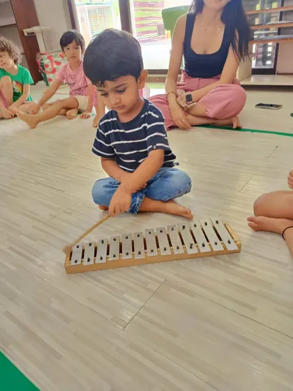 A young boy concentrates on playing a xylophone during our Bandra workshop, learning about melody and notes in a fun, hands-on way.