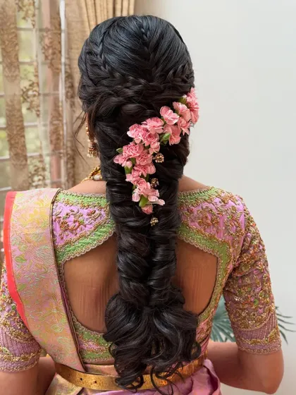 A close-up of the fishtail braid, highlighting the texture of the weave and the delicate placement of each flower. It's a romantic and feminine hairstyle.
