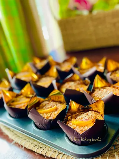 A tray of the beautiful peach and carrot muffins, with their golden tops and pretty liners.