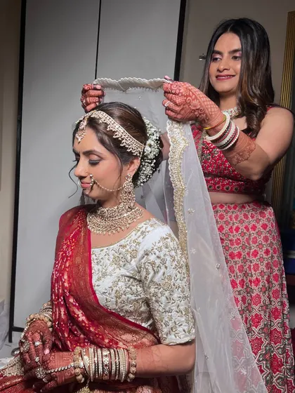 A sweet moment between the bride and her sister. The makeup is designed to be picture-perfect for all these cherished memories.