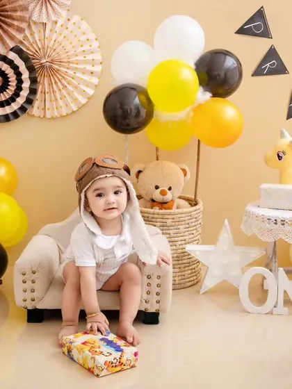 This little pilot is celebrating his first birthday with a travel-themed setup, complete with a toy plane and hot air balloon basket.