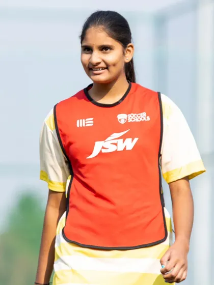 A player from our girls' academy smiles during a match. We foster an environment where girls can enjoy the game and build lasting friendships.