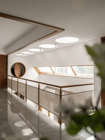 These images show the upper-level bridge and hallway, illuminated by both angled and circular skylights. The combination of different light sources ensures the core of the home is always bright and connected to the time of day.