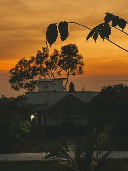 The silhouette of our ashram against a fiery sunset. This is the peaceful view that greets you at the end of each day, a perfect moment for reflection.