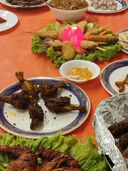 A beautiful spread of our most popular appetizers. This table features fried chicken drumsticks, sheesh kebabs, and a central platter of assorted tikkas, ready for guests to enjoy.