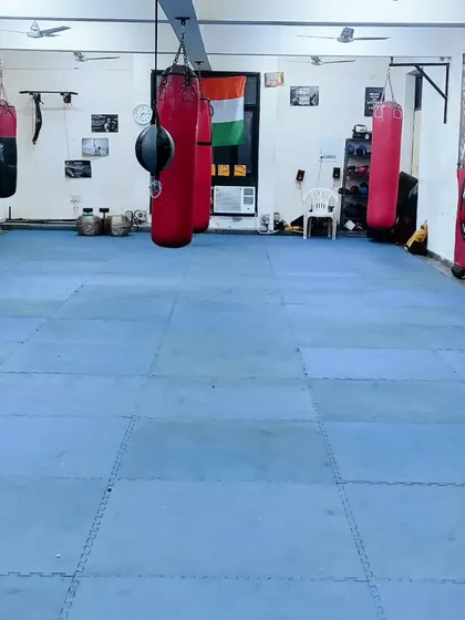 A wide shot of the Shaheed Bhagat Singh Boxing Academy. You can see our punching bags, open mat space, and the Indian flag proudly displayed.
