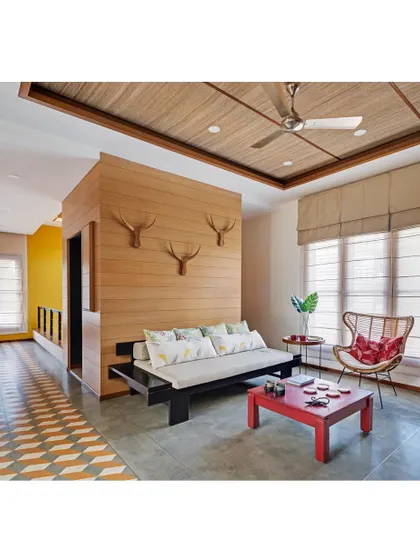 The family room in Nataraj House, showing the Indian divan and the transition from polished cement flooring to a patterned tile inlay.
