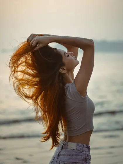 A dynamic shot capturing the movement of the model's hair in the sea breeze. It feels free and full of life.