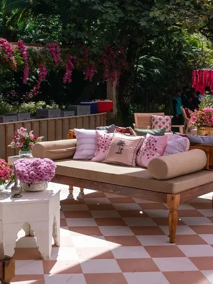 Cozy corners at our 'Pomegranate Spring' Mehendi, featuring wooden divans with quirky printed cushions. The mix of patterns and florals creates a fun, eclectic, and comfortable lounge space for guests.