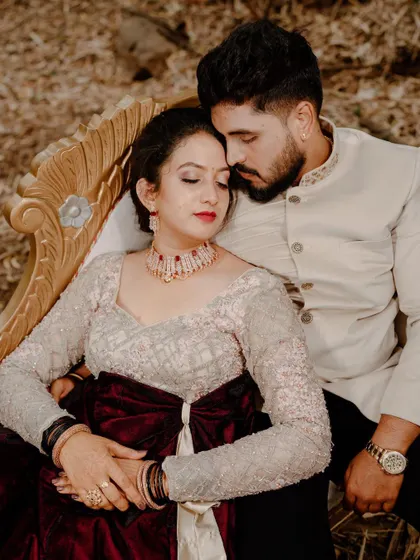 An intimate overhead shot of a couple seated together, capturing a quiet, romantic moment. The rich colors of their outfits add to the mood.