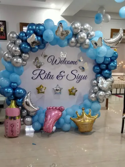 This celestial theme is a dreamy way to welcome a baby. The blue and silver balloon arch is decorated with moon, star, and crown foil balloons around a personalized "Welcome" backdrop.