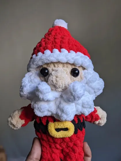 A jolly Santa Claus amigurumi, with a fluffy white beard and classic red suit, ready for the holidays.