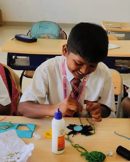 Students are engrossed in making rakhis, a craft activity that combines cultural learning with fine motor skill development.