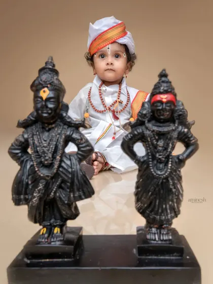 A creative shot focusing on the Vithoba and Rukmini idols, with the little Varkari devotee sitting peacefully in the background. This composition emphasizes the spiritual aspect of the theme.