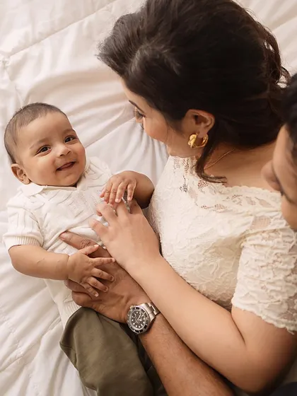 A baby's happy smile for his parents. This overhead shot captures a sweet, intimate moment of connection during a family session.