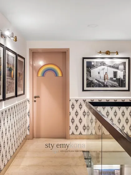 The rainbow on the door to the kids' room adds a playful touch to the otherwise sophisticated staircase gallery wall.