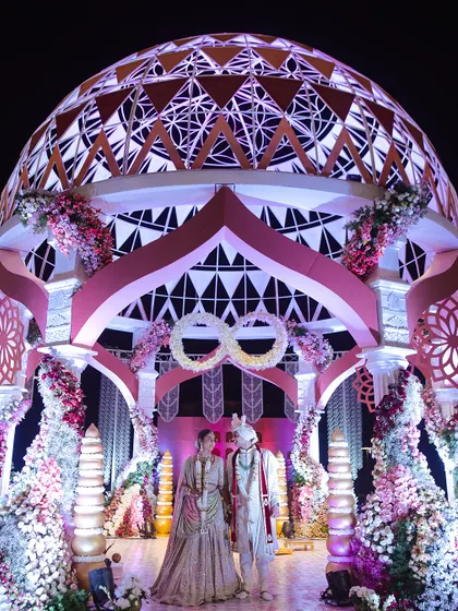 A breathtaking decor structure featuring a massive, intricately designed dome under which the couple stands. This is an example of how I use grand architectural elements to create unforgettable focal points.