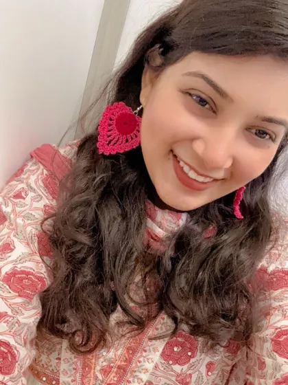 This is how my large, heart-shaped crochet earrings look when worn. They are handmade, super lightweight, and add a fun pop of bright pink to any outfit, making them a perfect statement piece.