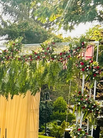 An outdoor engagement setup in a beautiful destination. The floral arch is designed to complement the natural green surroundings.