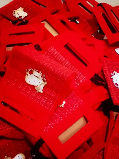 A pile of our red Pichwai cow tote bags, ready for a large order. This design is a classic bestseller for weddings and festivals.