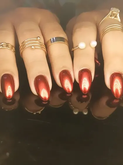 A stunning set of deep red cat-eye nails on almond-shaped extensions.