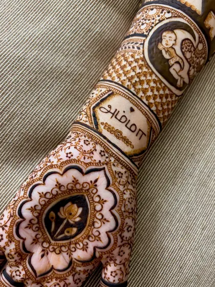 A close-up on the "Amma" (Mother) script and the baby-in-the-moon motif from a custom baby shower design.