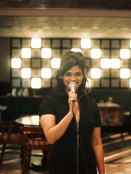 A candid moment while hosting a karaoke night at Daysie. The background features the venue's unique checkered light wall, which creates a great ambiance.