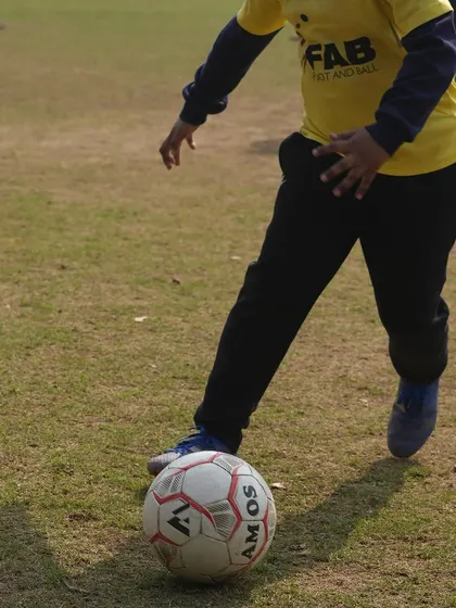 A close-up of a player's foot on the ball. This represents our focus on the fundamentals and mastering the basics of ball control.