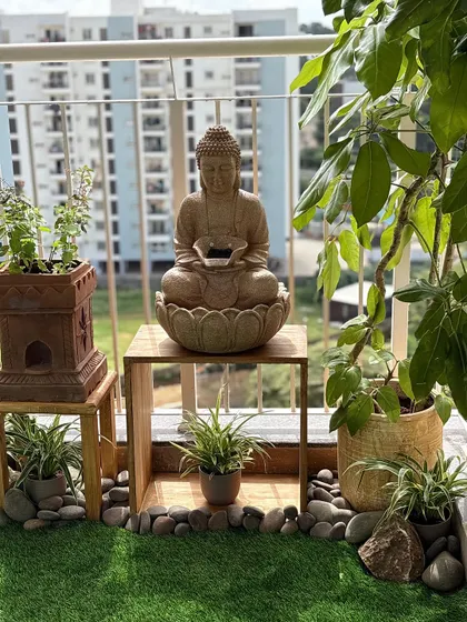 Creating a sense of calm is key. This peaceful corner features a solar-powered Buddha fountain, a traditional Tulsi Vrindavan, and plants that thrive in the sun, all arranged with natural pebbles to create a serene vibe.