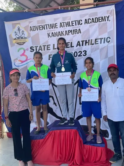 A gold medal performance in the 1500m at the Kanakapura State Athletic Meet. This athlete stands proudly at the top of the podium.