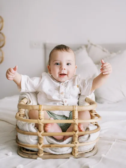 A seven-month-old boy giving a big thumbs-up. He's already a pro at photoshoots, this being his third session with me.