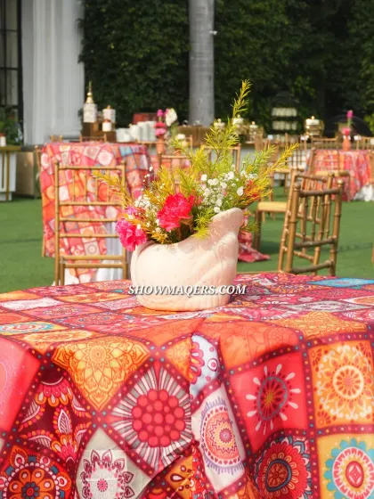 A close up of the colorful table setting from the Banaras themed event, featuring patterned linens and unique floral vases.