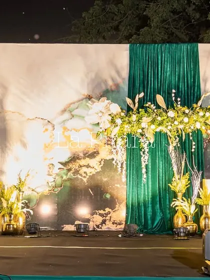 This is the main stage we designed for a corporate Diwali party for Inditex. The setup combined elegant emerald green draping with a modern, abstract backdrop and lush floral arrangements, creating a sophisticated and festive focal point for the event.