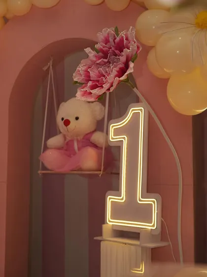 Small props like this teddy bear on a swing add a charming and detailed touch to the overall decoration, helping to build a cohesive and adorable theme.