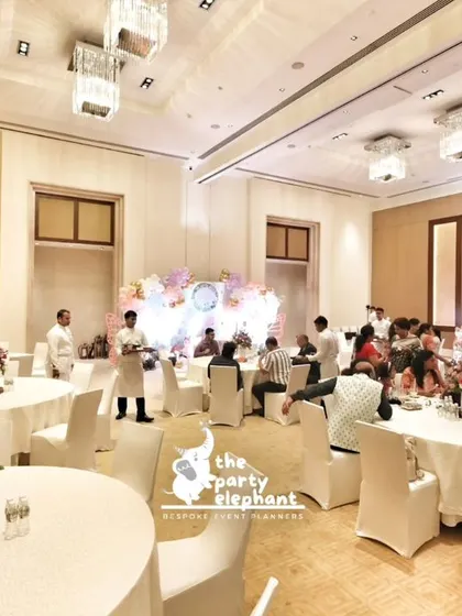 A wide view of the elegant butterfly fairy theme setup in a spacious banquet hall. We arranged guest seating with beautiful floral centerpieces to complement the main stage decor, ensuring a cohesive and immersive atmosphere.