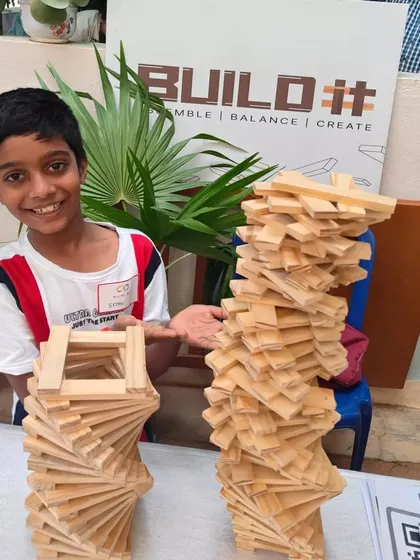 Look at that smile. This is the moment of pride and accomplishment that I strive to create in every workshop. After focusing, trying, and sometimes failing, seeing your own idea stand tall is an incredible confidence booster. This is how we build resilience, one block at a time.