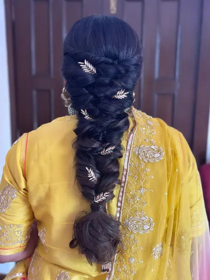 Unleash your inner queen with this regal braid. This intricate fishtail braid is adorned with glistening golden leaf accessories, creating a hairstyle that is truly fit for royalty.