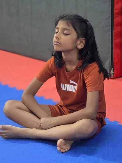 Centering the mind is a key part of our training. This young athlete takes a moment to breathe and focus, building the mental discipline required for gymnastics.