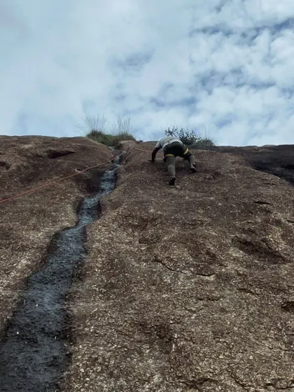 A climber tackles a route with a natural water groove, adding an interesting challenge.