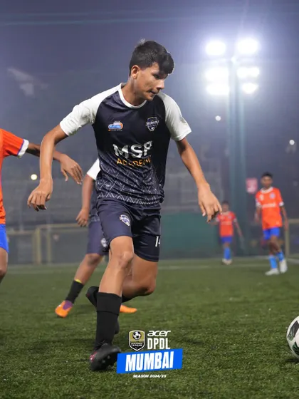 A player focuses on the ball, ready to make his next move in a training drill.