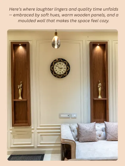 In the living area, warm wooden niches with soft backlighting create a perfect spot for displaying cherished decor. The moulded wall panels and tufted sofa add a layer of texture and coziness.