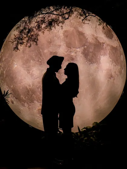 A classic silhouette of a couple in front of a giant moon. The simplicity of the shot allows their connection to be the main focus.