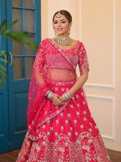 A full shot of a model in a gorgeous pink lehenga, showing how it can be styled for a wedding or a grand sangeet night.
