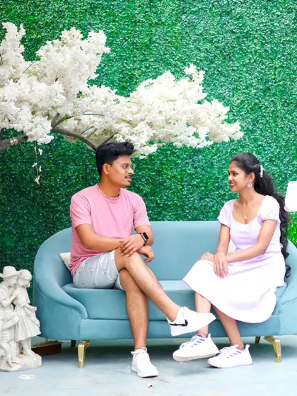A relaxed moment on a sofa against a green wall with a faux cherry blossom tree. This setup is perfect for cute, indoor pre-wedding shots.