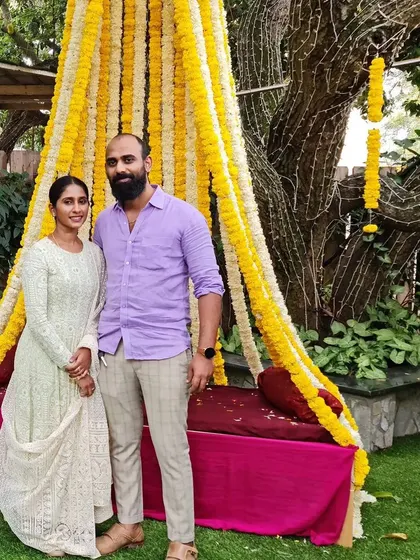 A lovely couple photo, with the client wearing her custom white Chikankari gown at an outdoor event.