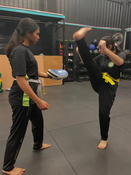 Kick-starting the week with a powerful high kick. This student demonstrates amazing flexibility and control during a pad work drill.