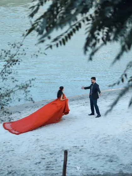 A playful interaction on the beach, with him reaching out to her. This captures a candid, story-like moment.
