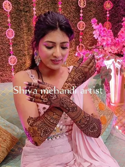 A bride displaying her elegant floral and paisley mehendi on the back of her hands, perfect for her special day.